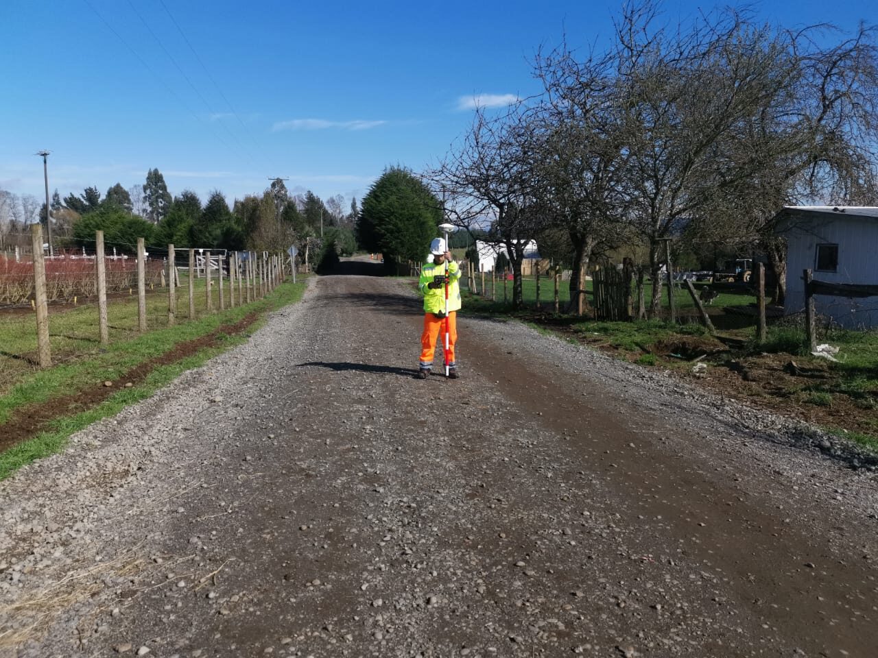 Equipo de topografía trabajando en camino rural
